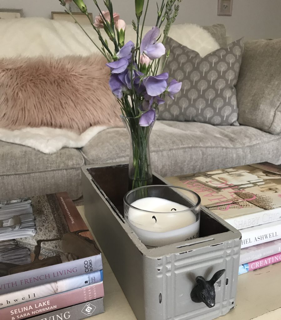 painted vintage drawer with hare handle, flowers and candleson coffee table with books