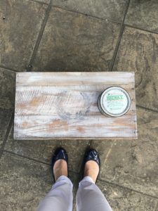 Painted DIY box with laurel wreath motif being waxed