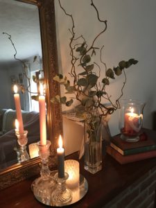 candles foliage and mirror on mantlepiece