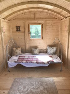 iron bed and rug inside Shepherds Hut