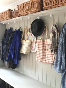 coat pegs and baskets in utility room