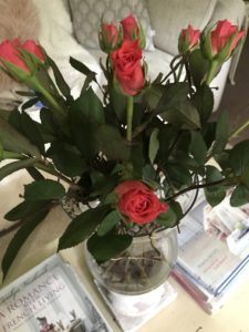 pink rose display in hurricane lamp