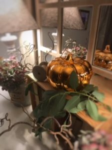 shiny pumpkin old books in vintage box with greenery and soft lighting