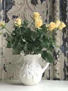 yellow rose display in white jug for room decor