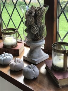  linen pumpkins candles books and pine cones create halloween decoration ideas