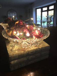 glass bowl dried roses fairy lights and french books in faffing session