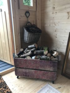 kindling in basket logs in decoupage box near stove