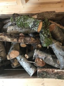 logs in box near to stove