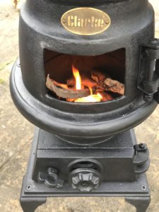 pot bellied stove with open door and fire