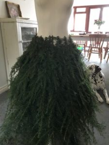 Fir tree branches create mannequin skirt for christmas decor