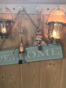 variety of hanging christmas decorations and welcome sign and tealights