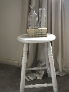 painted bar stool with books and dried flowers in vintage bowl