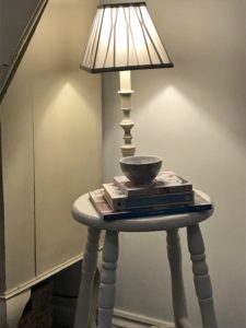 painted bar stool with lamp books and ceramic bowl