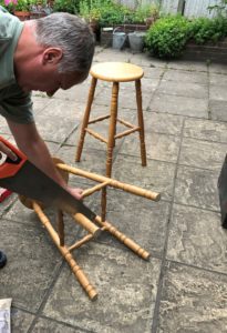 bar stools being sawed to correct height for use as tables