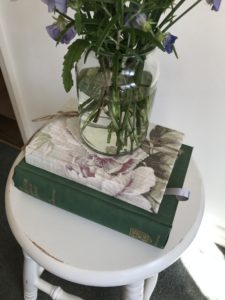 painted bar stool with books and flowers