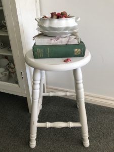 painted bar stool with books and dried flowers in vintage bowl