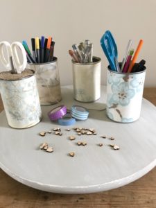 painted lazy susan with wallpapered tin cans scissors washi tape pens pencils and wooden hearts