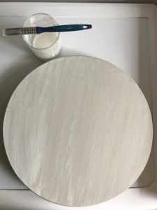 lazy susan with coat of chalk white paint paint brush and paint