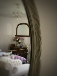 reflection of bed, mirror, chaise longue, chest of drawers and chandelier