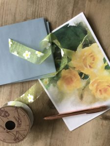 rose paper, ribbon, blue envelopes and pen for handwritten letter