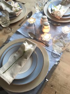 distressed plate charger in blue dining setting with candles and blue table runner