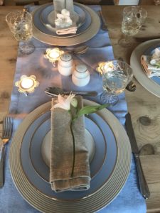 distressed plate charger in blue dining setting with candles and blue table runner