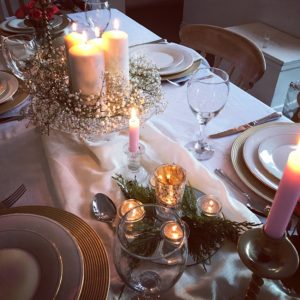 gold plate chargers on dining table with candles,, china, gypsophila and glasses