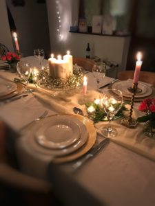 gold plate chargers on dining table with candles, china, gypsophila and glasses