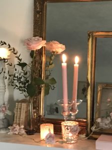 pink roses candles vintage french books rose garland and gilt mirror and frames on painted fireplace