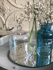 painted tray with gypsophila glass bottles and cloche