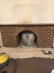 preparing brick fireplace with plastic and dust sheets before fireplace makeover