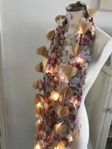 mannequin in many a paper garland with scarf and fairy lights