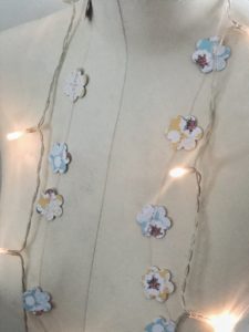 flower paper garland and fairy lights on mannequin