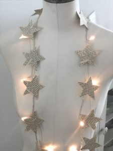 star paper garland and fairy lights on mannequin