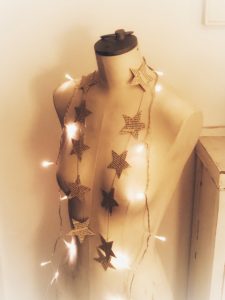 star paper garland and fairy lights on mannequin