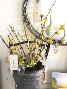 tin bucket with decorated yellow twigs as easter tree in spring decor