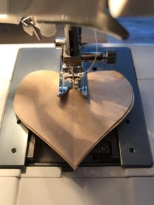 stacked brown paper hearts in sewing machine ready to make paper garland