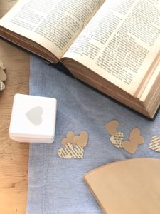 hole punch paper hearts coffee filter paper and vintage book preparing to make paper garland