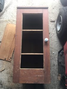 front panel of old pot cupboard removed to reveal shelves