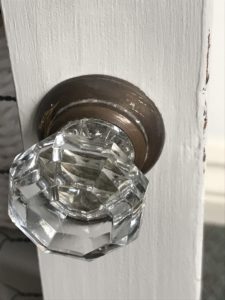 vintage glass door knob on painted and distressed grey pot cupboard door