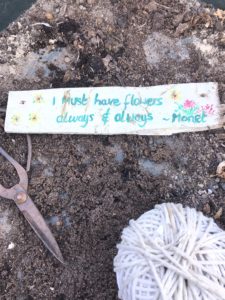 homemade signs in greenhouse with string soil and scissors