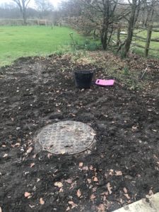 digging ground over to prepare for wildflower garden showing draing covder bucket and kneeler