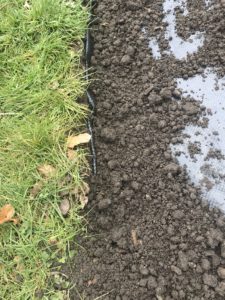 grass, top soil and weed suppresent being laid to create a wildflower garden