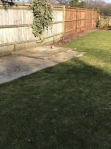 concrete base green lawn and fence where vegetable garden will be