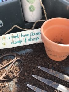 handpainted sign terracotta pot string scissors and fork in vegetable garden