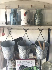 shelf and hook system with jugs, bottles, zinc bee stenciled hanging pots and others