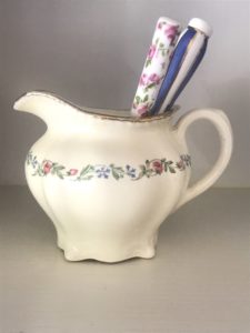 cream jug with flowers and gold rim and vintage teaspoons