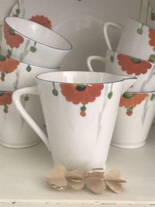 orange gerbera jugs and tea set with paper heart garland