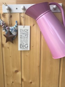 pink enamel jugs on shaker rail with sign star and fabric dog