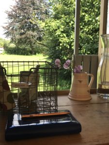 jugs water jug storage basket blue diary and gold pen on wooden desk in shepherds hut